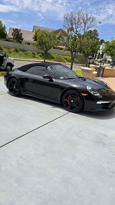 Porsche 911 Cabriolet negro visto desde adelante a la izquierda, terminado