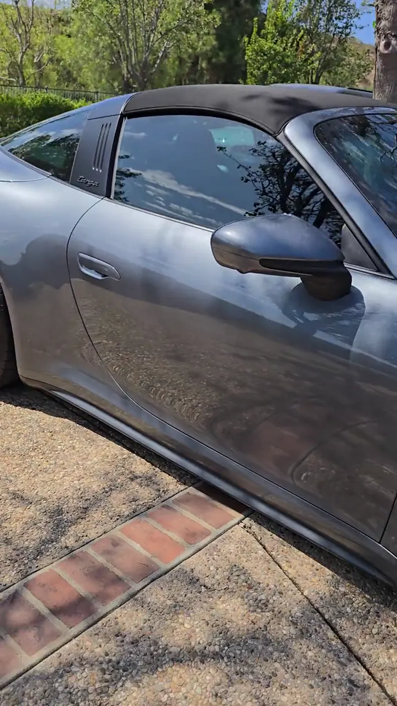 Vuelta de 360° a un Porsche 911 Targa gris grafito terminado, con el reflejo parejo en toda la carrocería